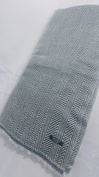 Grey and white herringbone cashmere blanket laid flat showing full pattern and fringe