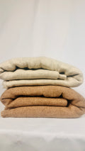 White plain cashmere blanket draped over a wooden rail