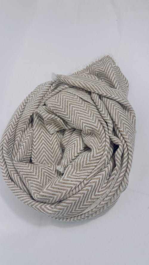 Beige herringbone cashmere scarf styled in a soft rolled arrangement