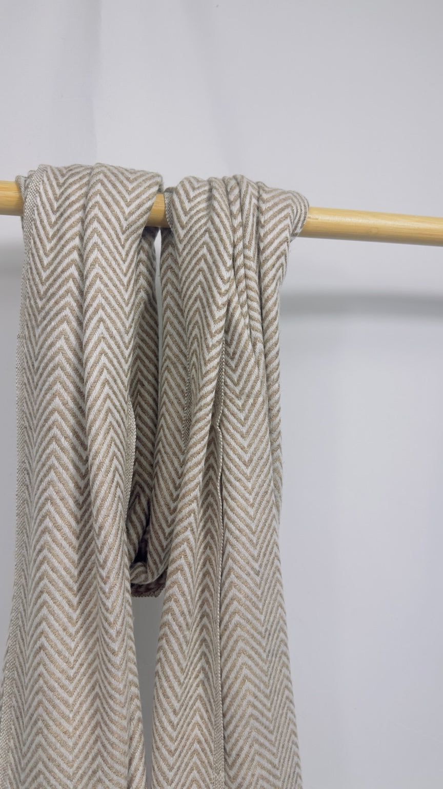 Beige herringbone cashmere scarf loosely draped to show the weave