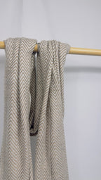 Beige herringbone cashmere scarf loosely draped to show the weave